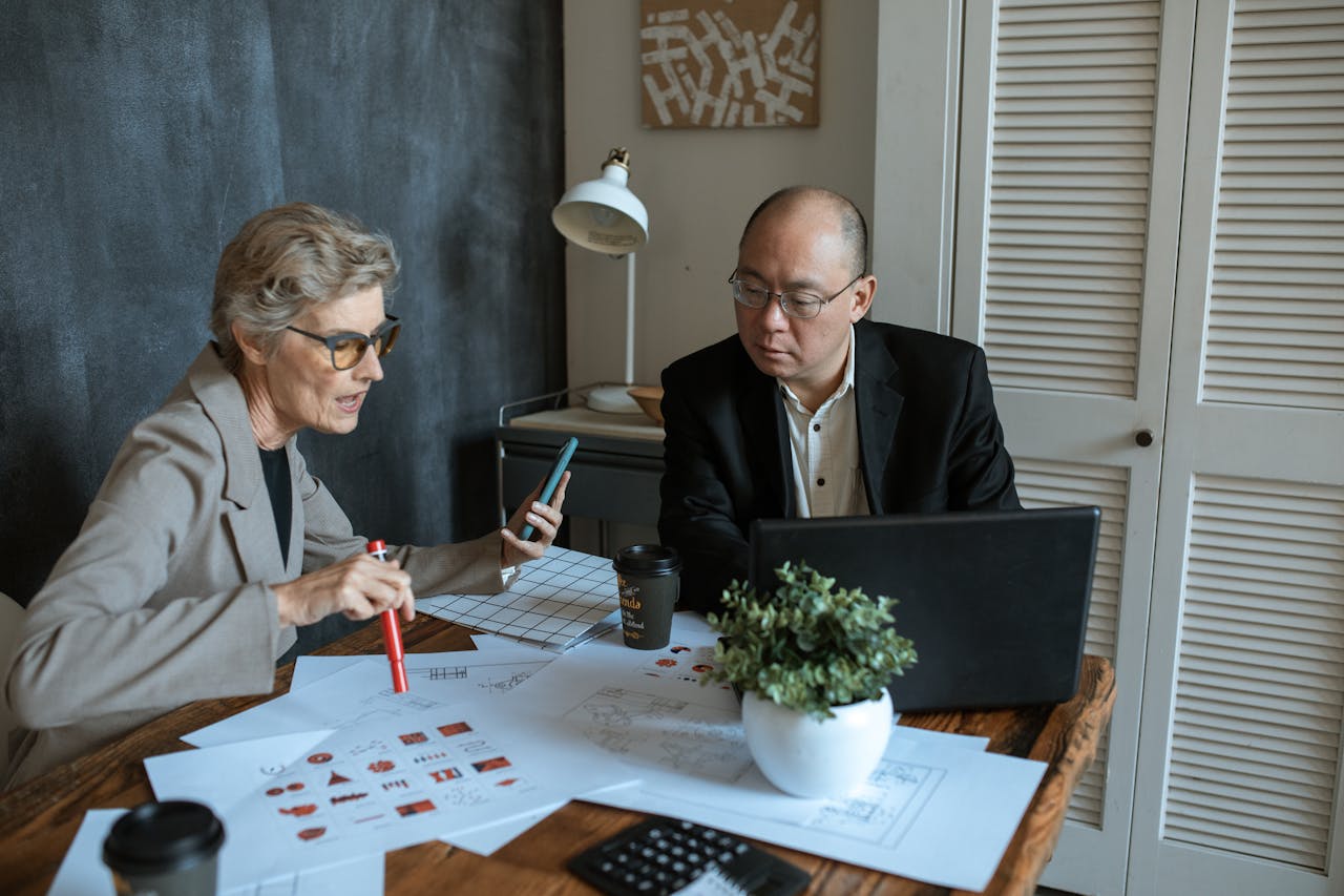 Two business professionals collaborating in a modern office setting for a project.